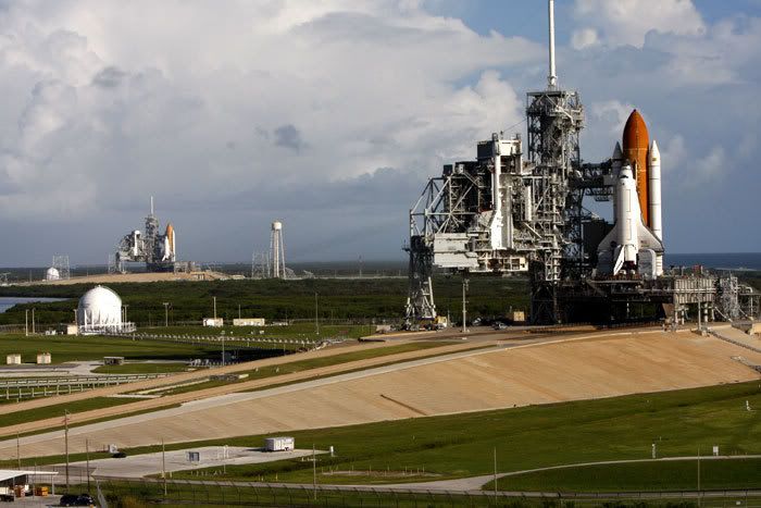 Space shuttle Atlantis stands ready for launch at Kennedy Space Center's Pad 39A in the foreground, while in the background, at Pad 39B 1.6 miles away, Endeavour begins preps for a potential rescue mission to Atlantis if she is found damaged during next month's flight to the Hubble Space Telescope.