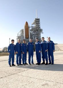 The crew of STS-119 pose in front of space shuttle Discovery at Launch Pad 39-A at Kennedy Space Center, Florida, on January 20, 2009.