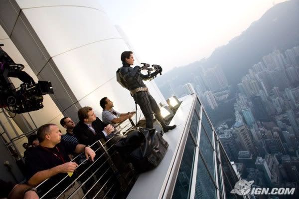 Director Christopher Nolan and his crew look on as Christian Bale rehearses a scene for THE DARK KNIGHT on a skyscraper overlooking Hong Kong.