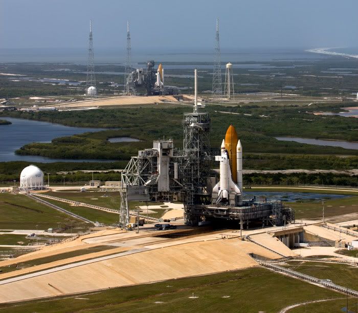 Space shuttle Endeavour (background) joins her sister Atlantis (foreground) at Launch Complex 39, on April 17, 2009.