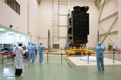 Technicians gaze at the SELENE spacecraft in a processing facility in Japan.