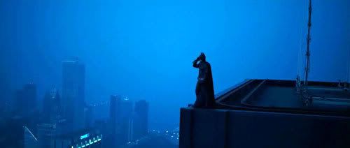 Batman stands atop the ledge of a skyscraper in Hong Kong.