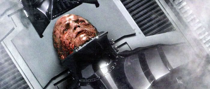 Anakin gazes on as Vader's mask is being lowered onto his face.
