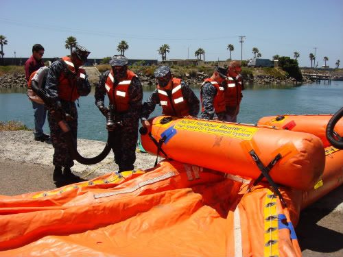 Navy sailors inflating a skimmer