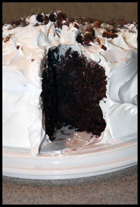 Chocolate Layer Cake with Fluffy White Frosting on a White Platter