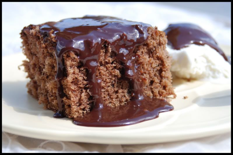 A piece of chocolate cake with hot fudge sauce drizzled over it