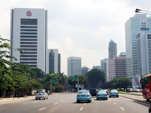the blue cars are taxis in jakarta's main road