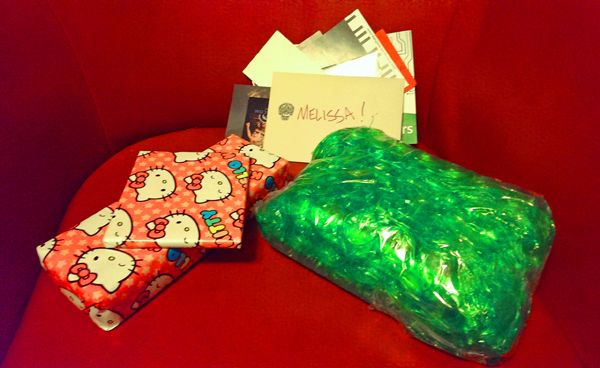 image of two presents wrapped in Hello Kitty wrapping paper, a present wrapped in green bubblewrap, a birthday card addressed to me, and a stack of junk
