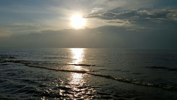 image of the sun setting over the water