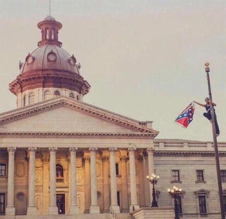 image of Bree Newsome, clinging to the flag pole high up in the air next to the capitol, with the Confederate flag in her hand
