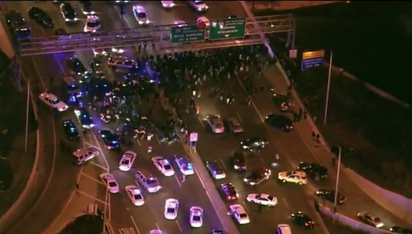 ariel photograph of protesters in Chicago blocking an interstate, facing a line of police cars