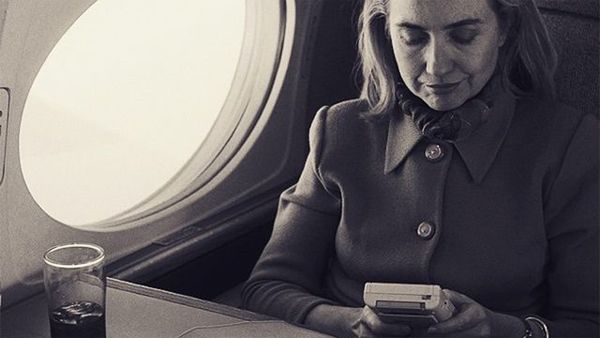 image of Hillary Clinton, then First Lady, on Airforce One, playing a Game Boy