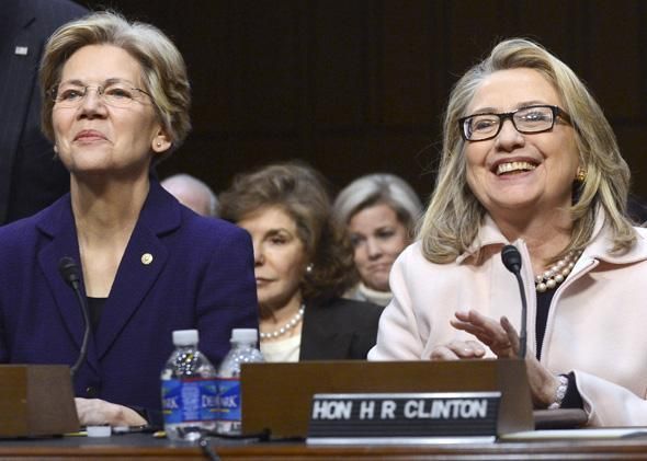 image of Elizabeth Warren and Hillary Clinton sitting on a Congressional panel beside one another, both smiling