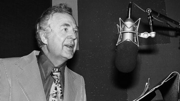 black and white image of Don Pardo, an older white man, speaking into a microphone