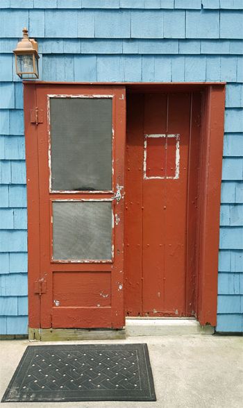 image of a red door on a blue beach house