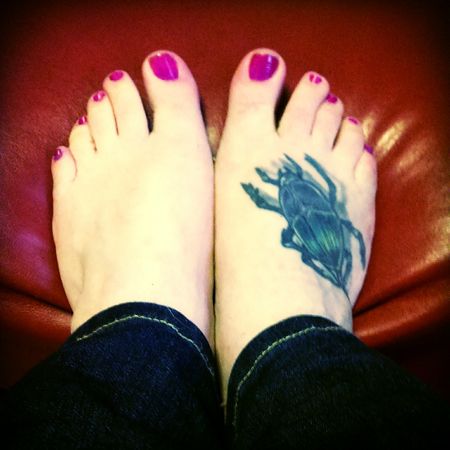 image of my feet with bright pink toenails; there is a tattoo of a beetle on my right foot