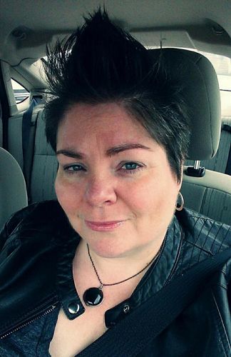 image of me in my car, wearing my black moto jacket over a slate grey t-shirt and with a black stone necklace