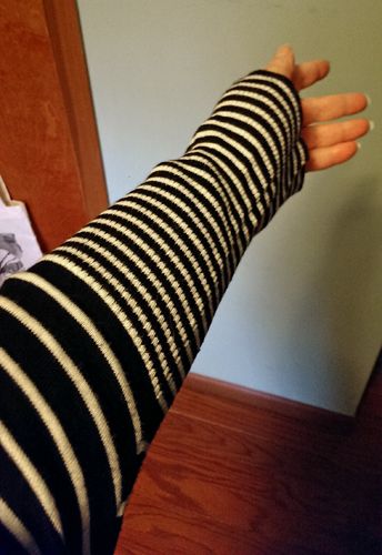 image of my outstretched arm, showing the sleeve pattern on the sweater, which goes from thicker stripes to thinner stripes mid-forearm