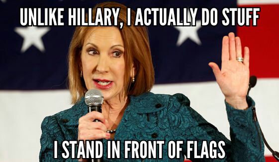 image of Carly Fiorina, a thin, white, older woman, standing in front of a US flag, to which I've added text reading: 'Unlike Hillary, I actually do stuff. I stand in front of flags.'