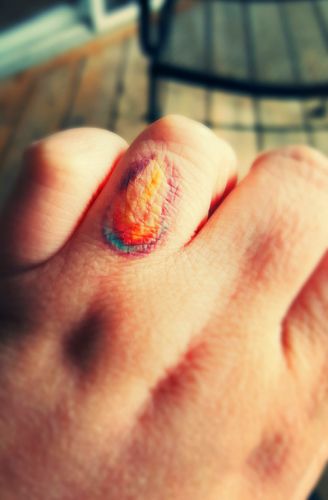 image of my left hand with a tattoo of a flame emerging from darkness on my ring finger