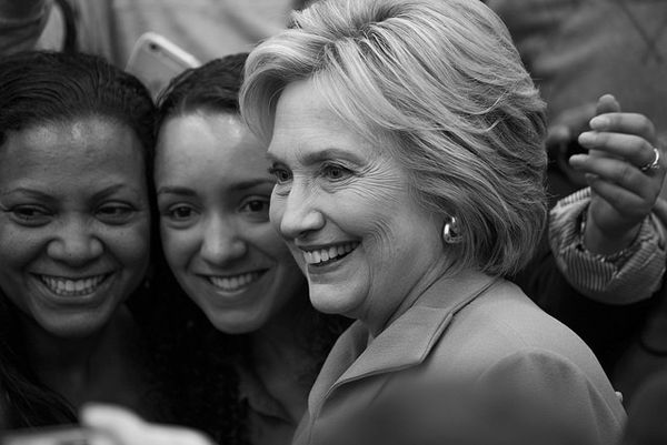 black and white photo of Hillary Clinton posing for a selfie with a black woman and a woman who appears to be white or Latina