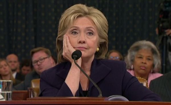 image of Hillary Clinton testifying, with her chin in her hand, looking contemptuous