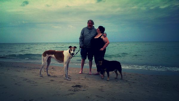 image of Iain and me at the beach, with the dogs; I am looking up at Iain and we are both smiling