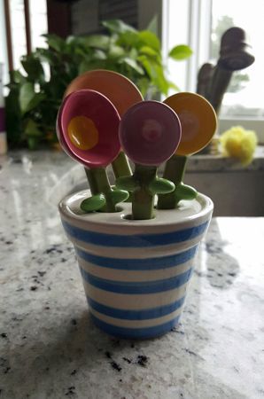 image of a set of small measuring spoons designed to look like flowers sitting in a vase