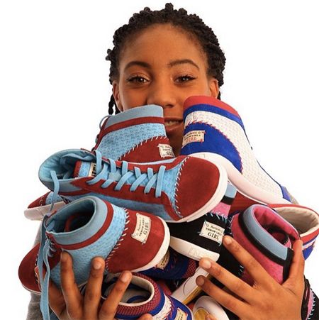 image of Mo'Ne Davis, a teenage black girl, posing with an armful of her sneakers