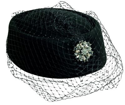 image of a black pillbox hat decorated with a rhinestone brooch and black netting