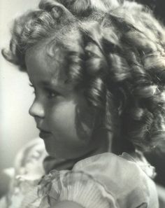 image of Shirley Temple in profile, sporting her classic ringlet hairstyle