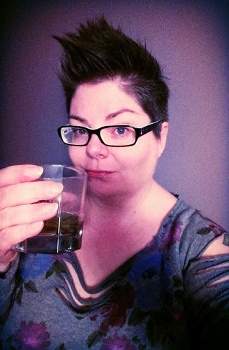 image of me in a purple room, holding up a tumbler of booze