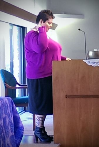 image of me taken from the side; I am standing a podium, giving a speech