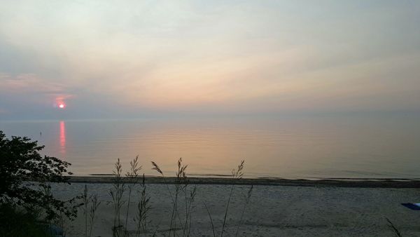 image of the sun setting over Lake Michigan on a hazy evening