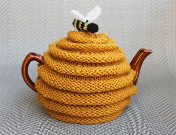 image of a teacozy designed to look like a beehive with a bee sitting on top