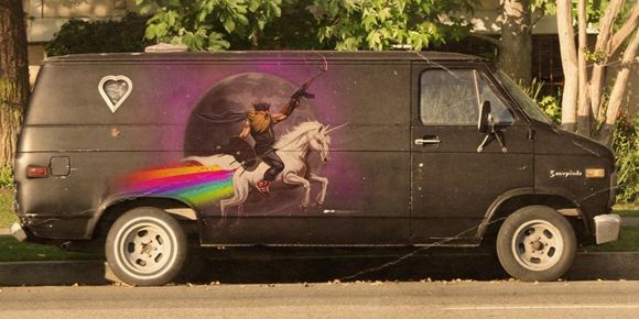 image of a van painted with the image of some bearded dude riding a unicorn