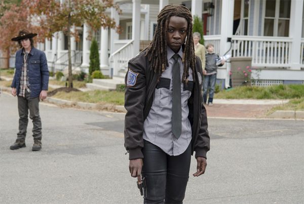 image of Michonne in her constable uniform, holding a pistol at her side and looking super pissed