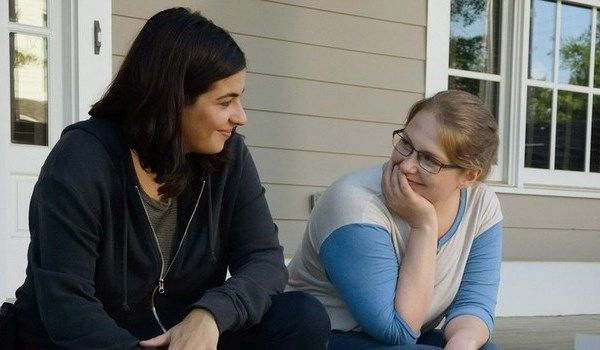 screen cap from The Walking Dead of Tara and Denise sitting on a stoop, looking at each other