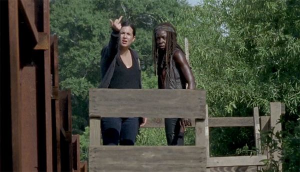 screen cap from The Walking Dead of Tara and Michonne standing on a platform; Tara is flipping off Grimes, who is offscreen