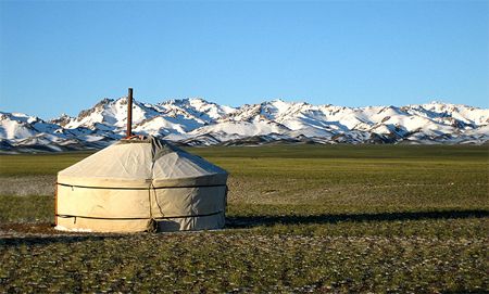image of a yurt on a plain with mountains in the distance