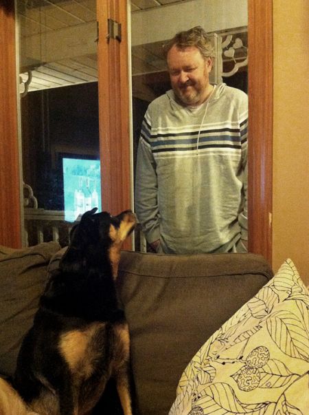 image of Iain standing outside the window, looking down at Zelda who is looking up at him