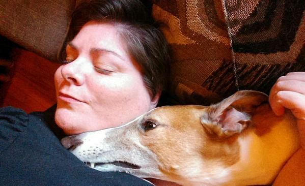 image of me napping on the couch with Dudley; his long snout is resting across my neck