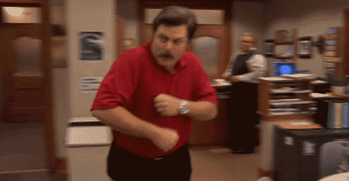 gif of Ron Swanson dancing across a room while wearing a Bobby Knight basketball coaching shirt and making the 'traveling' sign