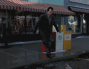 moving image from Groundhog Day of Bill Murray about to step in a puddle, then stopping, and another guy walking by and stepping right into it, making Murray grin