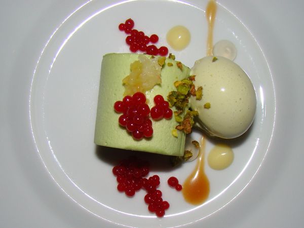 image of a beautifully presented pistacchio dessert with many different colorful and textural components