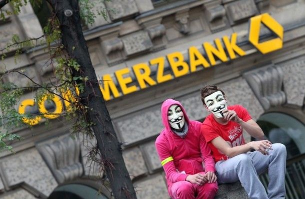 Demonstrators wearing V-masks sit in front of a Commerzbank branch as they take part in a protest march as part of the 'Occupy Frankfurt' movement in Frankfurt am Main, on October 29, 2011 to protest against the financial system.