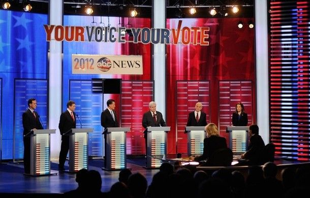 scene from Saturday night's GOP debate in Iowa: Standing behind podiums on an appropriately patriotically decorated stage are Rick Santorum, Rick Perry, Mitt Romney, Newt Gingrich, Ron Paul, and Michele Bachmann.