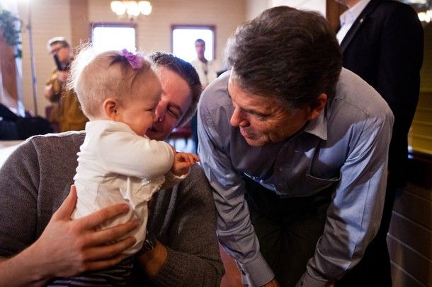 image of Rick Perry leaning over and talking to a baby