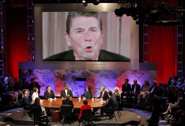 image of the roundtable debate with video of Ronald Reagan appearing on a huge screen over the seated candidates
