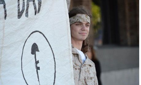 image of injured Occupy Oakland protester Scott Olsen holding a sign at a protest before he was injured